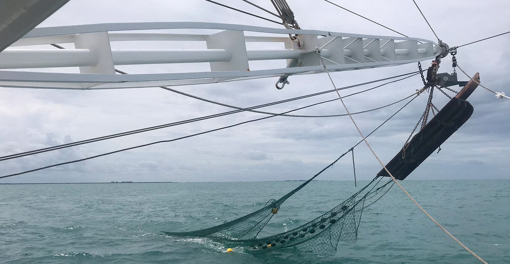 Close view of relocation trawling equipment extending from a vessel